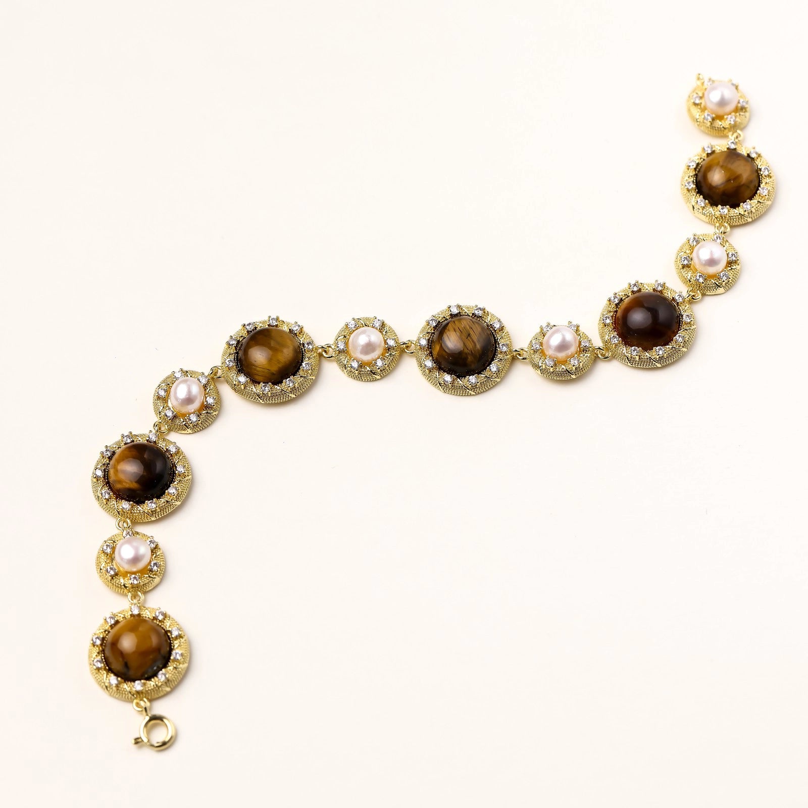 Side angle highlighting cabochon tiger’s eye and pearl spacing