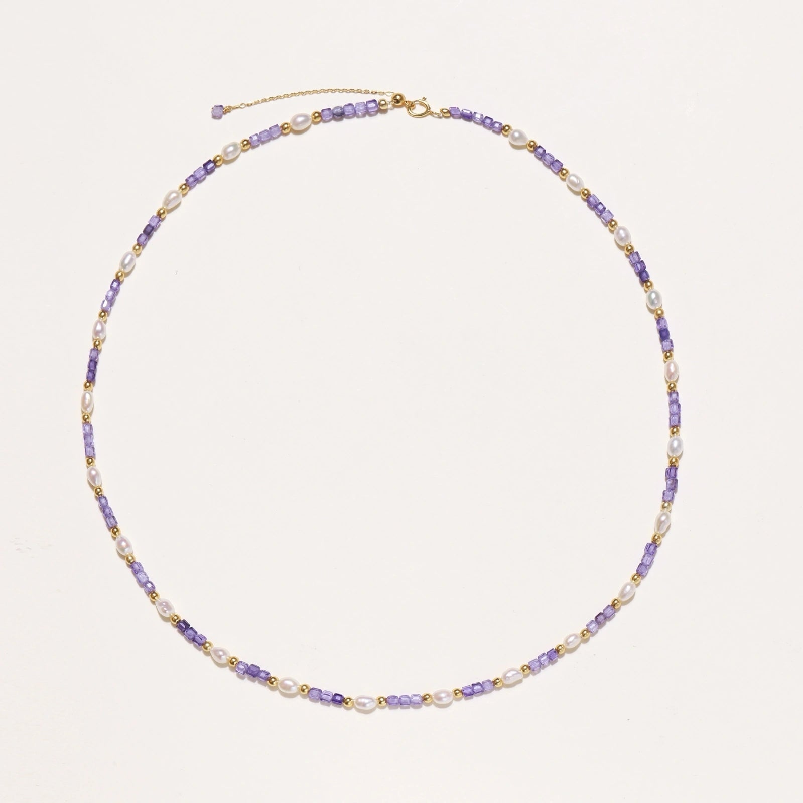 Close-up of lavender zirconia stones and freshwater pearls on gold vermeil necklace