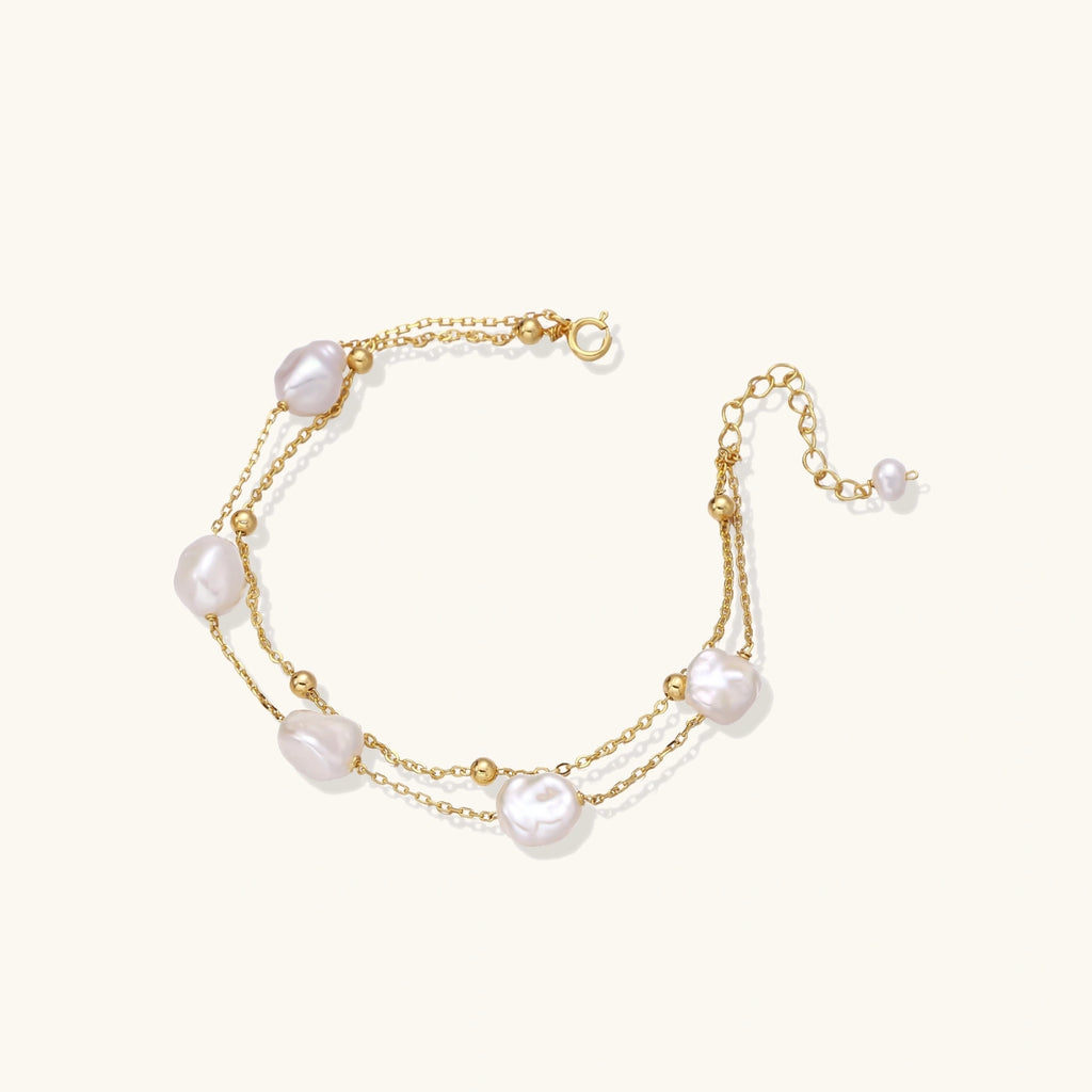 Flat lay of baroque pearl double chain bracelet on neutral surface
