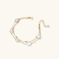 Flat lay of baroque pearl double chain bracelet on neutral surface
