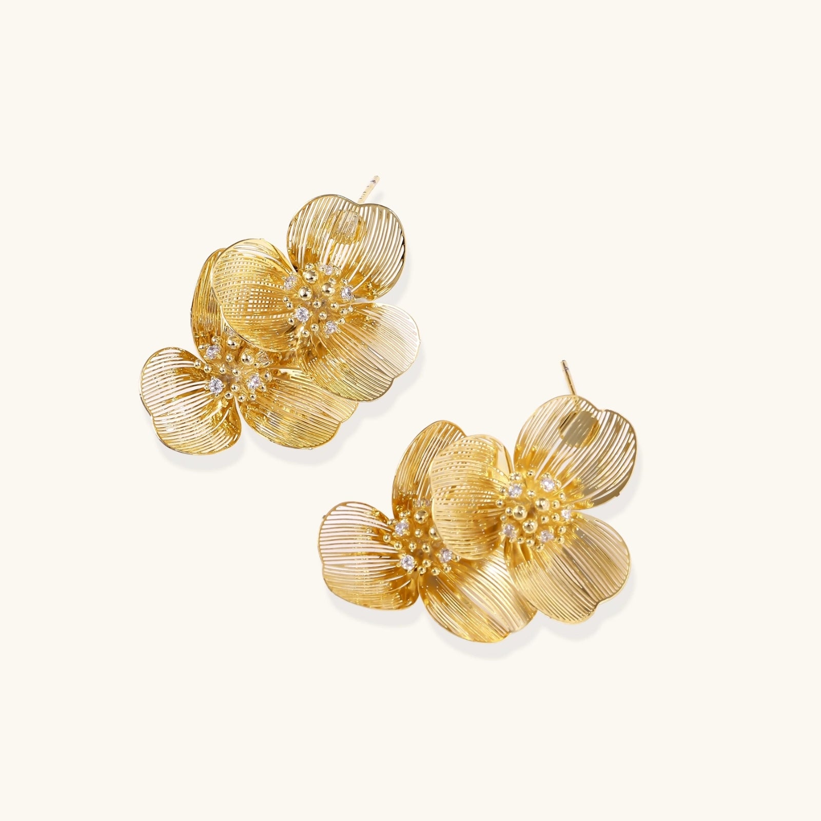 Front angle of double bloom gold earrings with crystal center detail