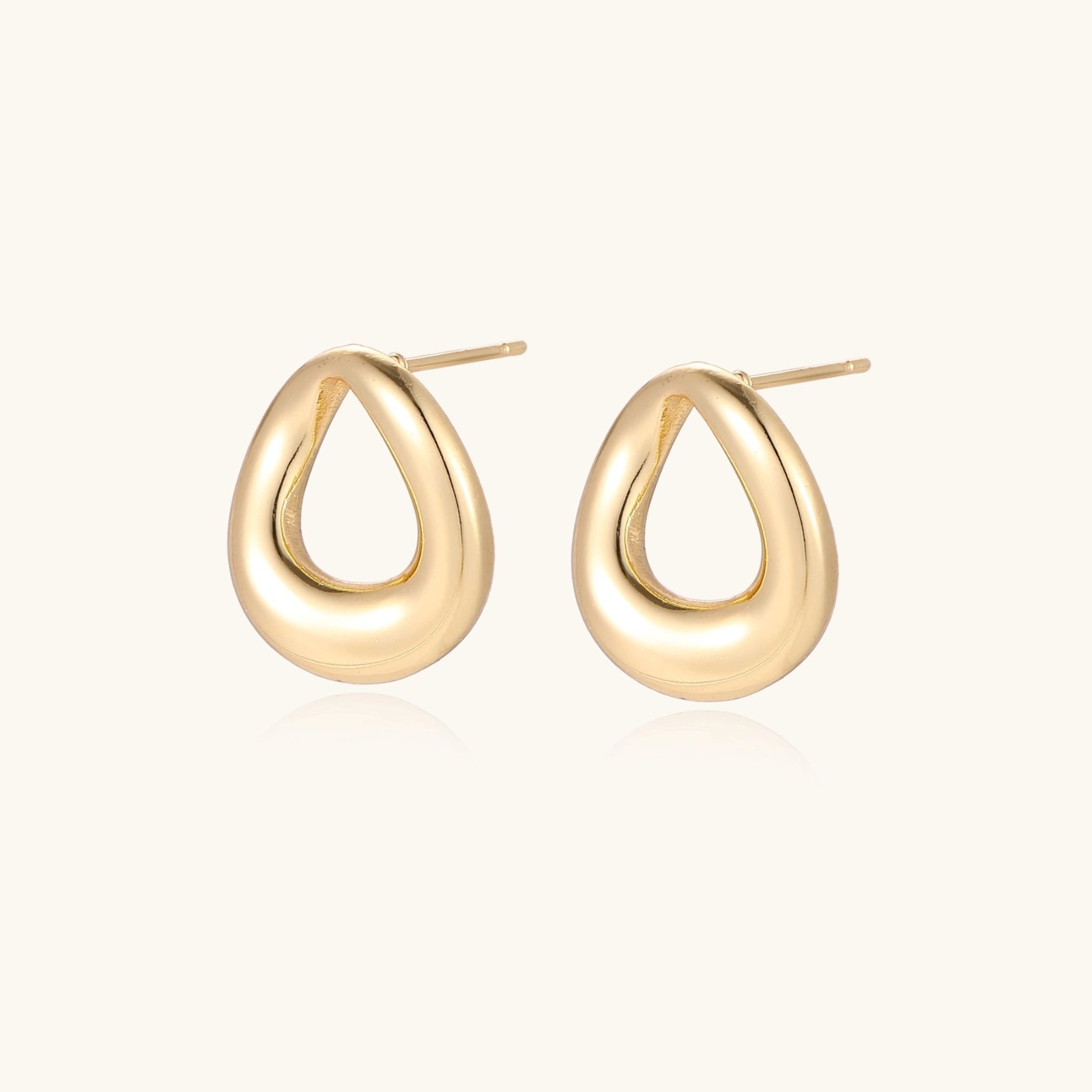 Close-up of polished gold plated loop stud earrings