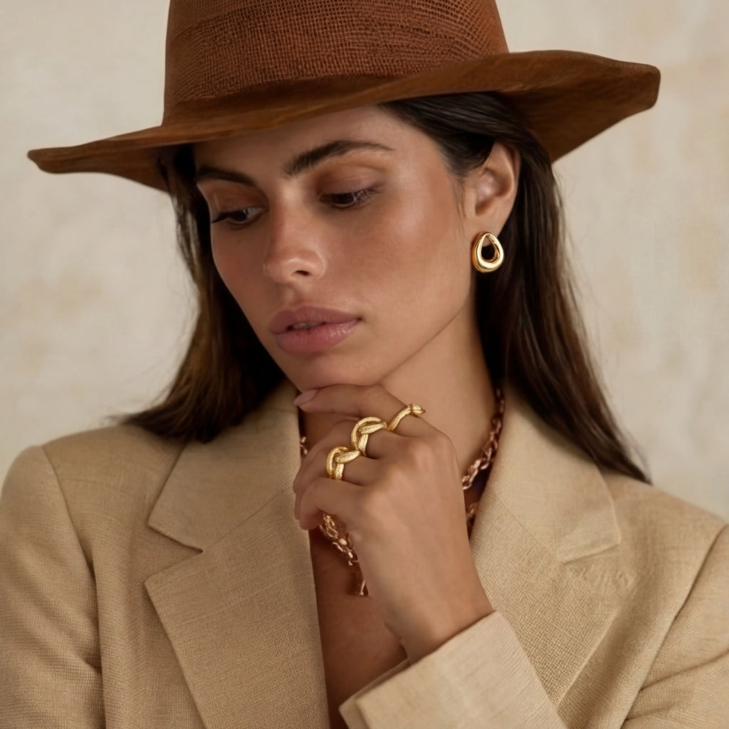 Model wearing GlacierFox Elements golden loop stud earrings in gold plated stainless steel
