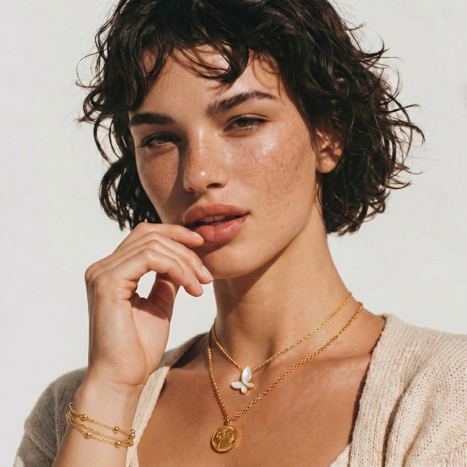 Model wearing GlacierFox Elements golden orbit triple strand bracelet in gold plated stainless steel