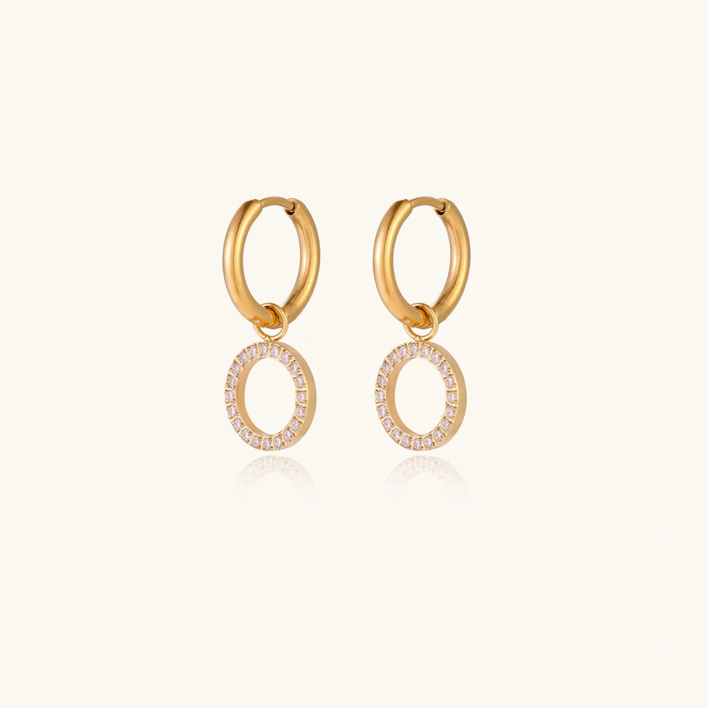 Side angle of gold huggie earrings with cubic zirconia detailing