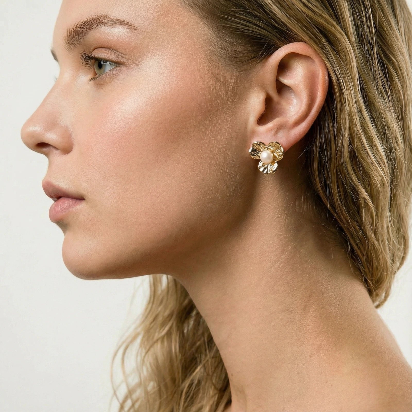 Model wearing GlacierFox Elements pearl bloom stud earrings in gold plated eco-brass