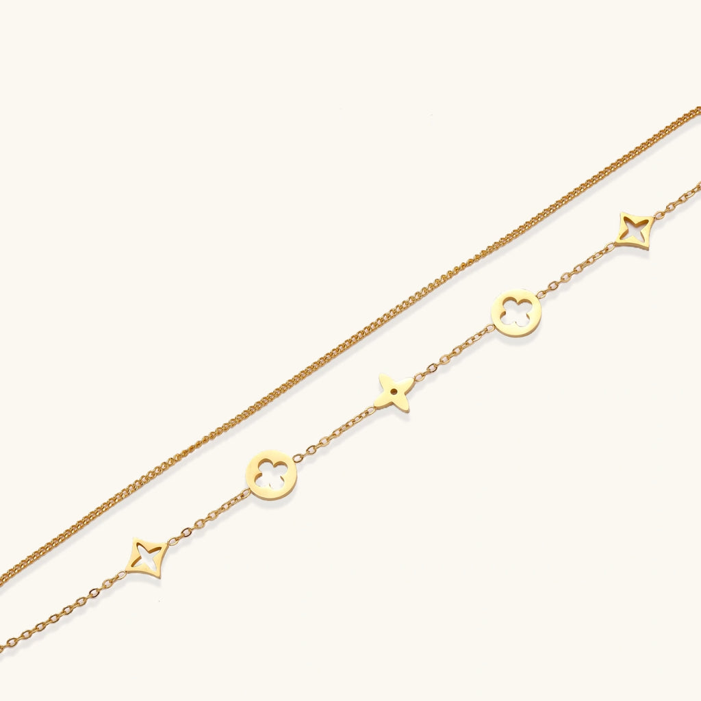 Close-up of star and quatrefoil clover charms on double chain bracelet