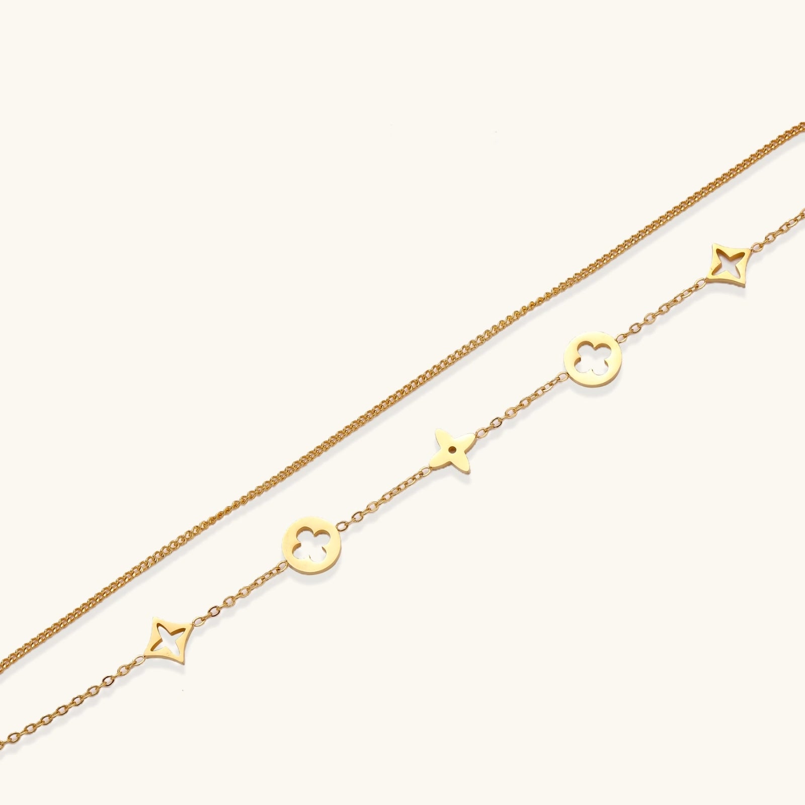 Close-up of star and quatrefoil clover charms on double chain bracelet
