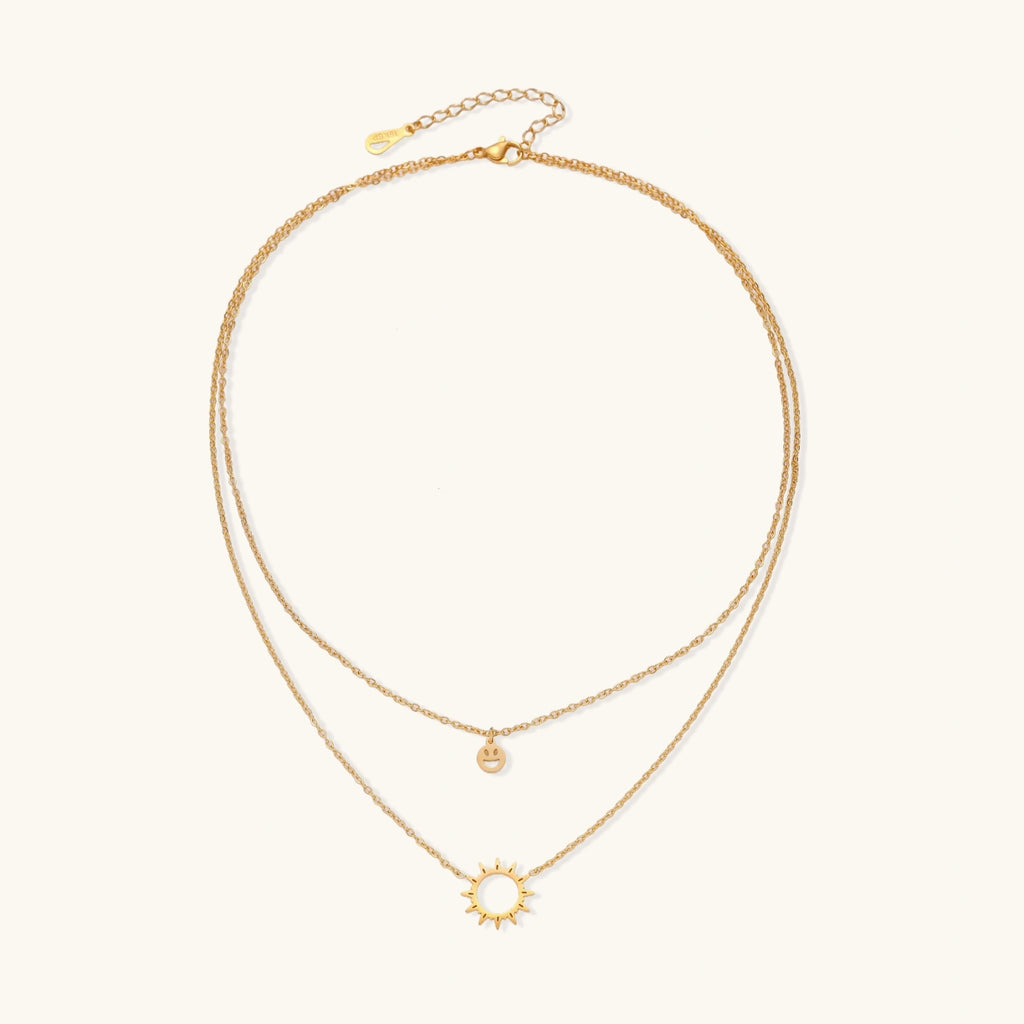 Front view of layered necklace with sun and smiley pendants