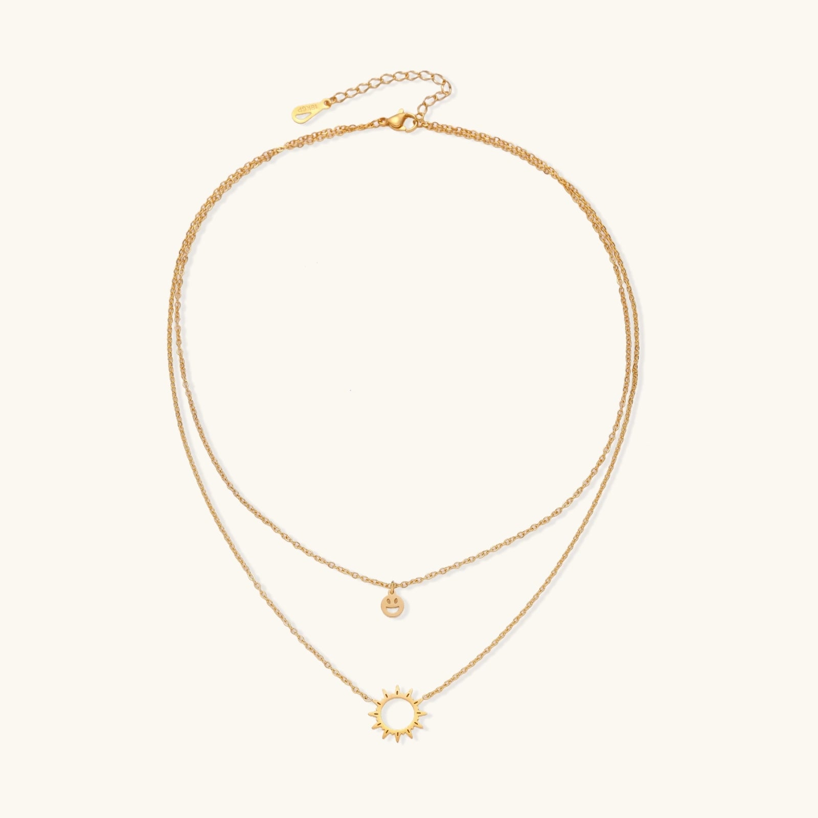 Front view of layered necklace with sun and smiley pendants