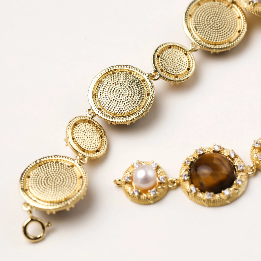 Close-up of tiger’s eye stone next to freshwater pearl