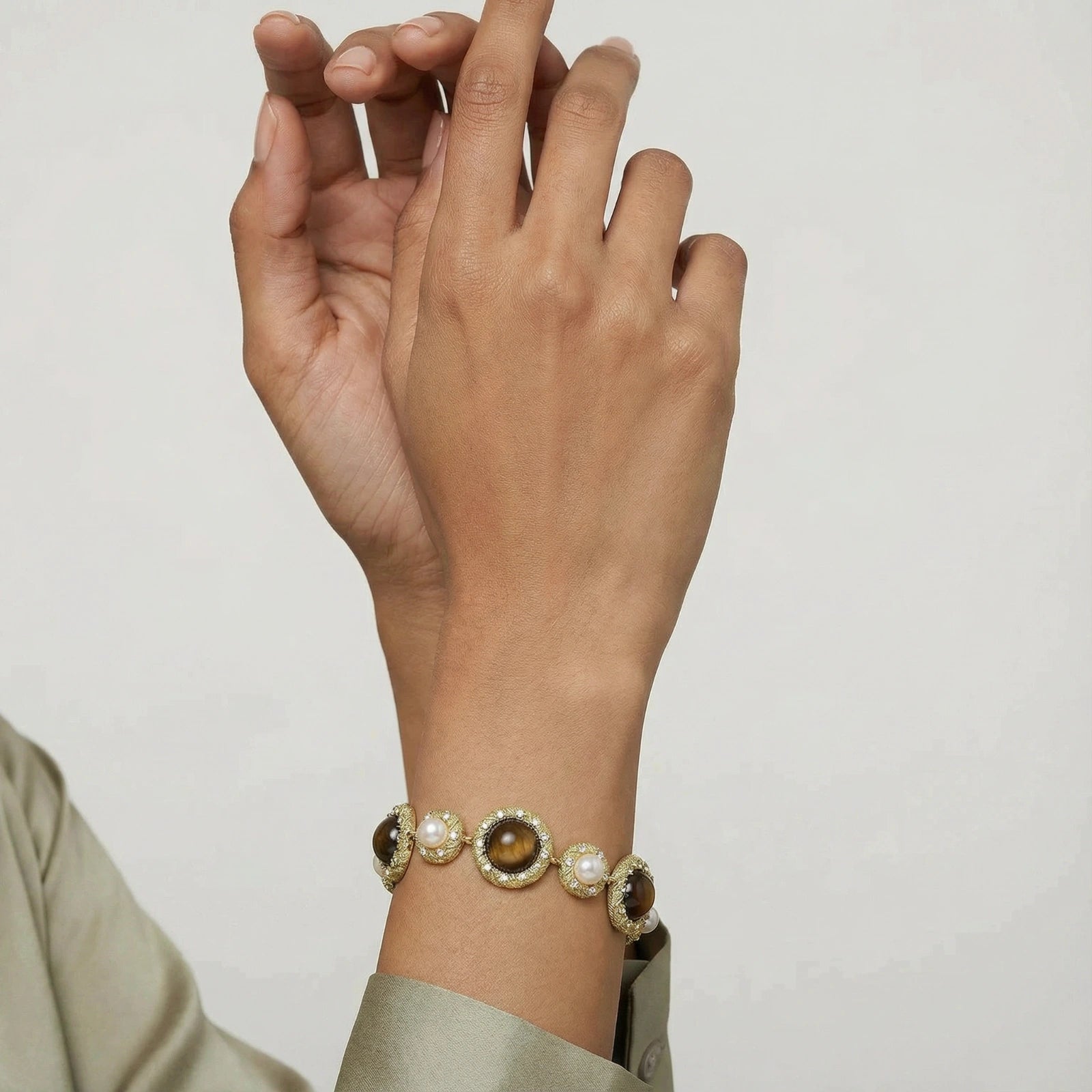 Close-up of bracelet on wrist showing tiger’s eye stones and pearls