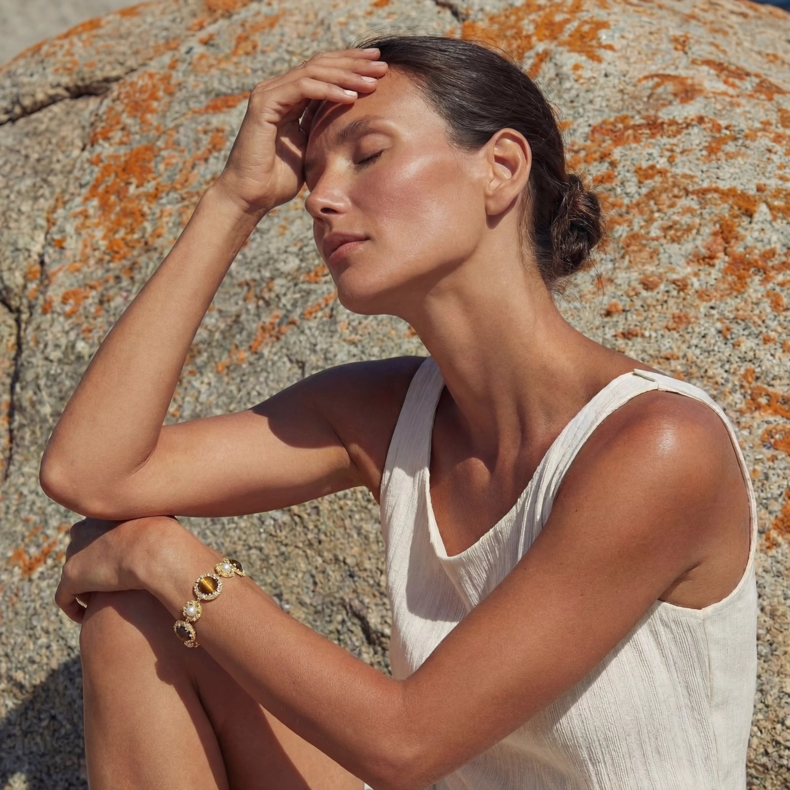Model wearing GlacierFox Elements tiger’s eye and pearl link bracelet in gold plated 