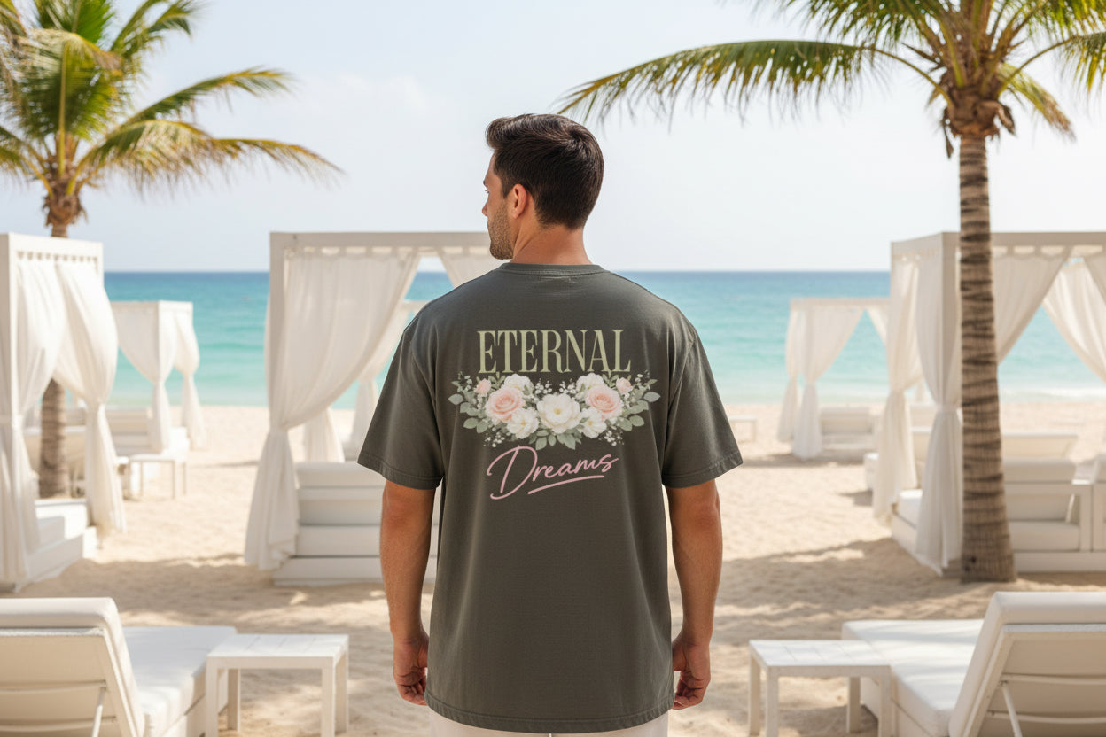 Model wearing statement series T-shirt looking towards the ocean on a beach