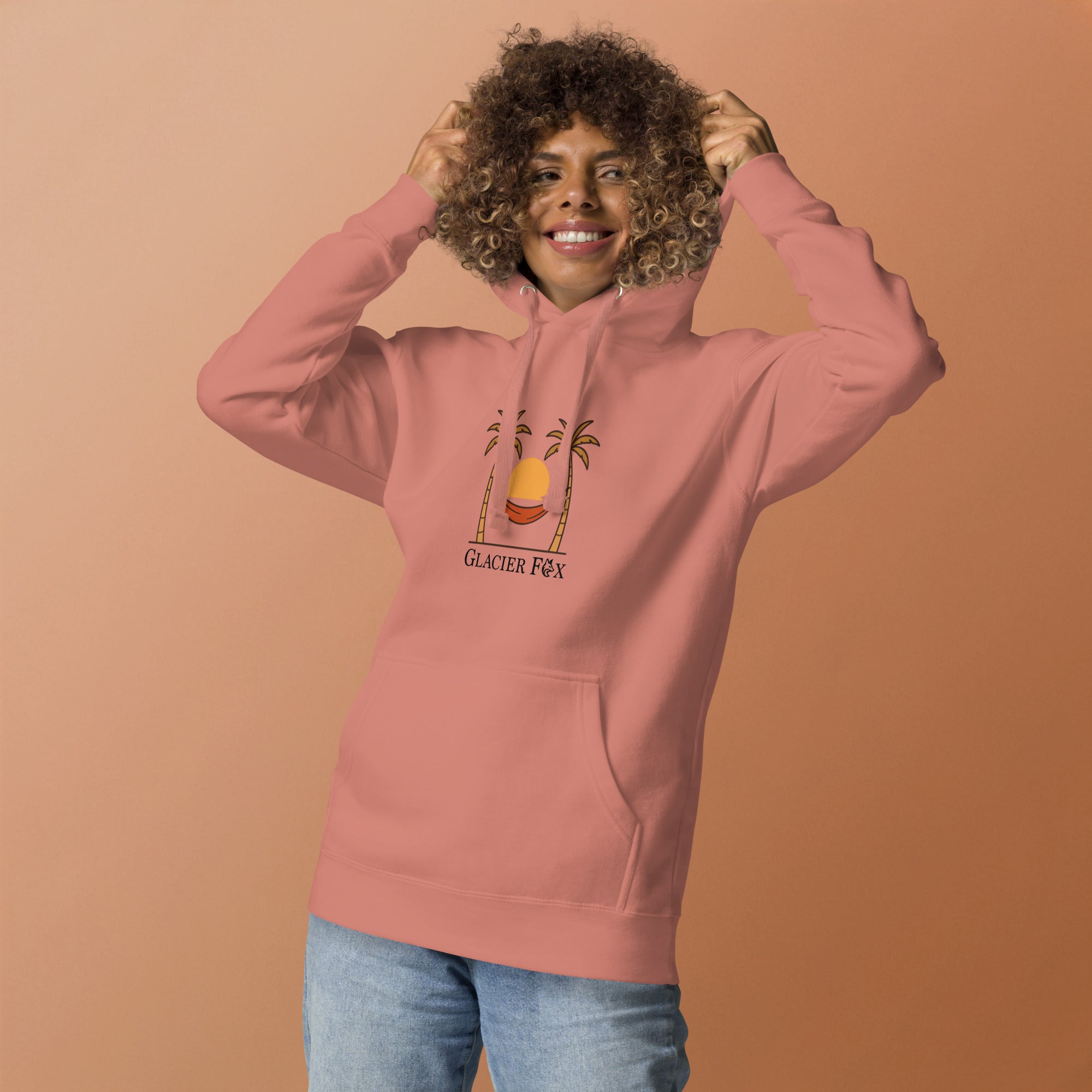 Model wearing GlacierFox women’s Sunset hoodie featuring a sunset design with the GlacierFox logo on the front and relaxed streetwear fit in Dusty Rose