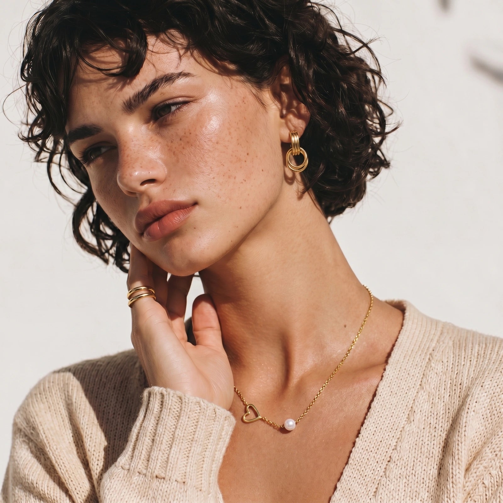 Model wearing GlacierFox Elements linear loop drop earrings in gold plated stainless steel